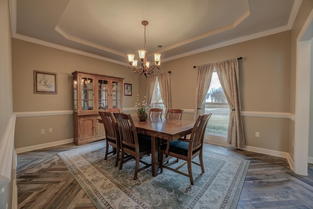 dining space with dark parquet flooring, a raised ceiling, and a notable chandelier