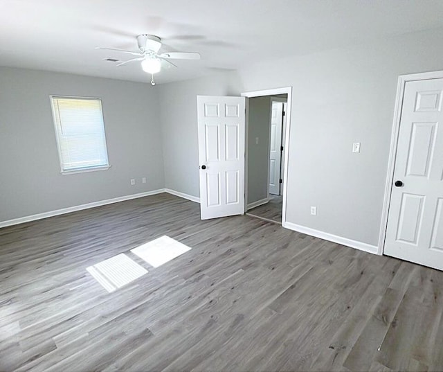 unfurnished bedroom with ceiling fan and dark hardwood / wood-style floors