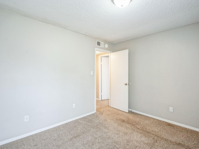 carpeted spare room featuring a textured ceiling