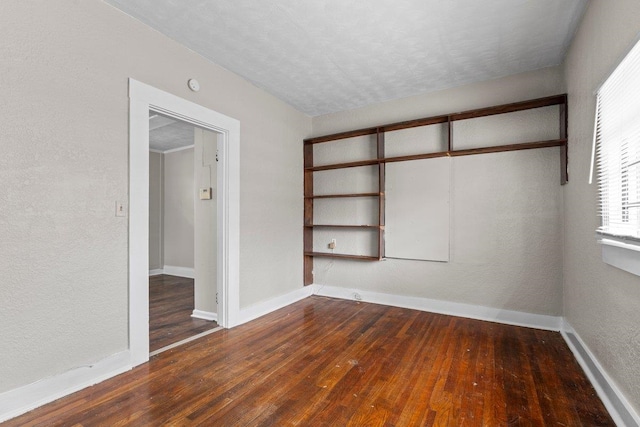 unfurnished bedroom with dark hardwood / wood-style floors, a textured ceiling, and a closet