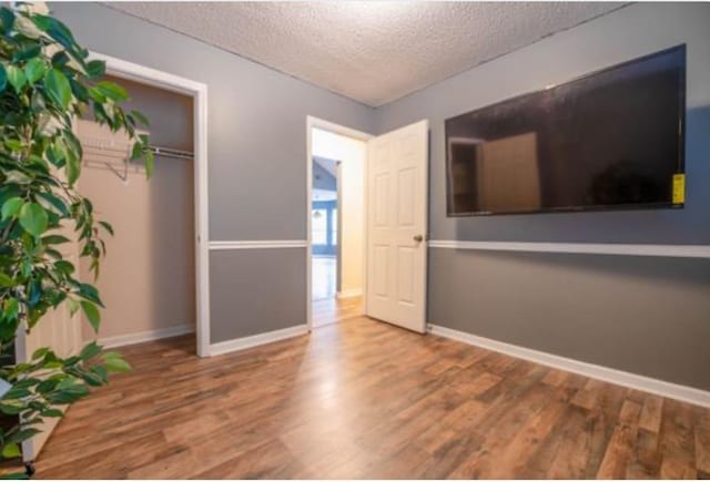 unfurnished bedroom featuring a textured ceiling and hardwood / wood-style flooring