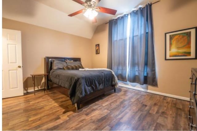 bedroom featuring dark hardwood / wood-style floors, ceiling fan, and lofted ceiling