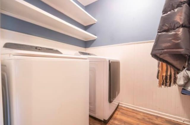 clothes washing area featuring hardwood / wood-style floors and separate washer and dryer