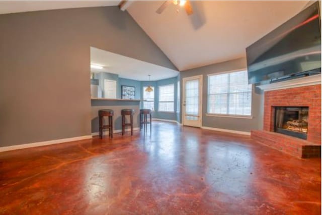 unfurnished living room with ceiling fan, lofted ceiling with beams, a fireplace, and concrete floors