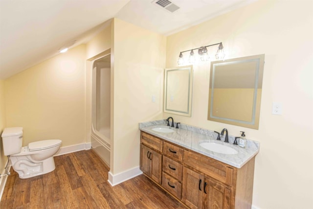 bathroom featuring hardwood / wood-style floors, vanity, toilet, and lofted ceiling