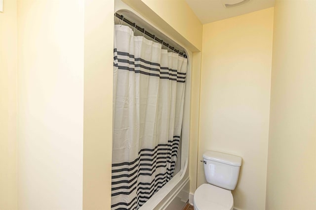 bathroom with shower / bath combination with curtain and toilet