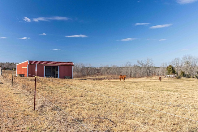 view of yard with a rural view and an outdoor structure