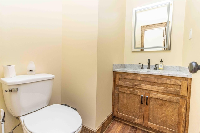 bathroom with wood-type flooring, vanity, and toilet