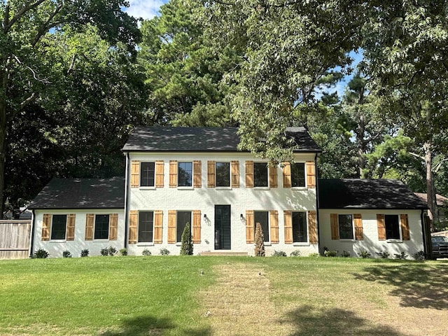 colonial inspired home with a front lawn