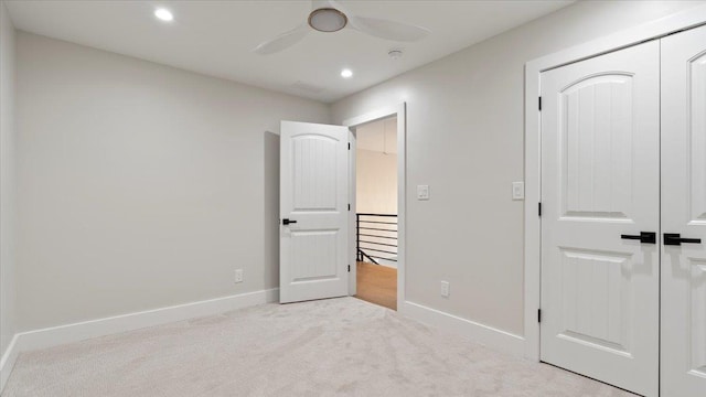 unfurnished bedroom featuring light carpet, a closet, and ceiling fan