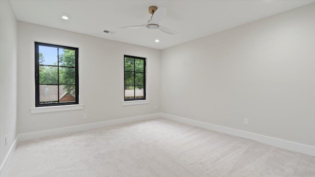 carpeted empty room featuring ceiling fan and a wealth of natural light