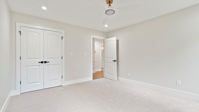 unfurnished bedroom with ceiling fan, light carpet, and a closet