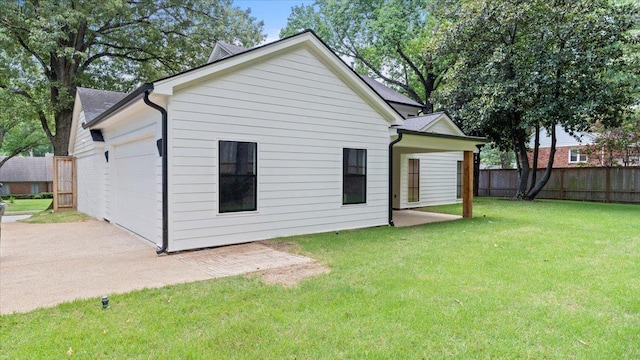 rear view of property with a lawn and a garage