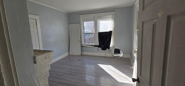 unfurnished room featuring wood-type flooring and ornamental molding