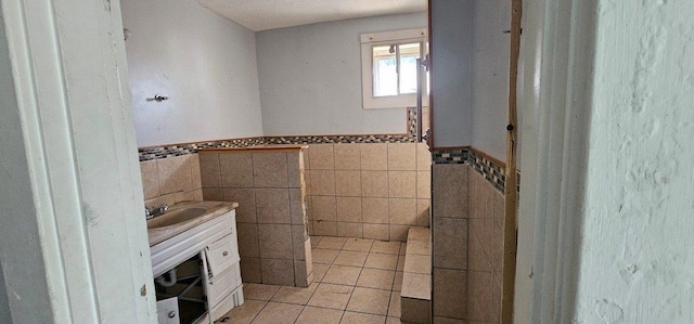 bathroom with tile patterned floors, vanity, and tile walls