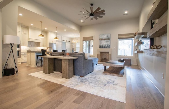 living room featuring ceiling fan and light hardwood / wood-style flooring