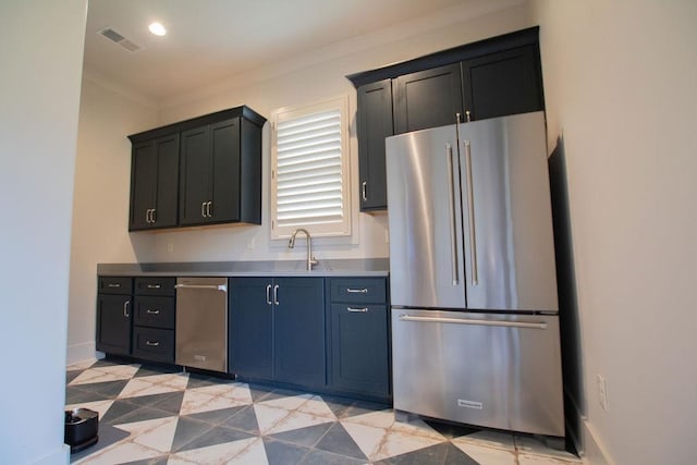 kitchen with stainless steel refrigerator, crown molding, and sink