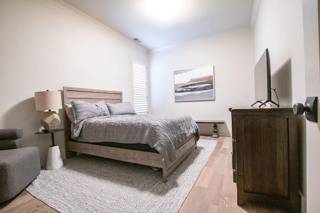 bedroom with light hardwood / wood-style floors and ornamental molding