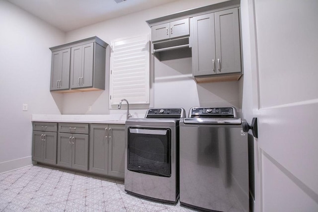 laundry area with cabinets, independent washer and dryer, and sink