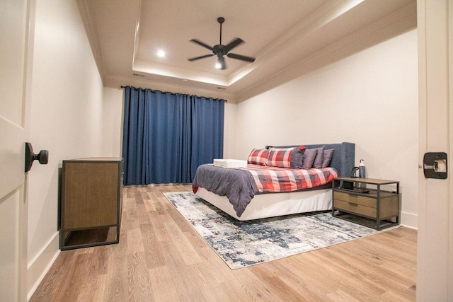 bedroom featuring a tray ceiling, ceiling fan, and hardwood / wood-style flooring