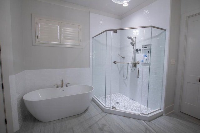 bathroom featuring tile walls and independent shower and bath