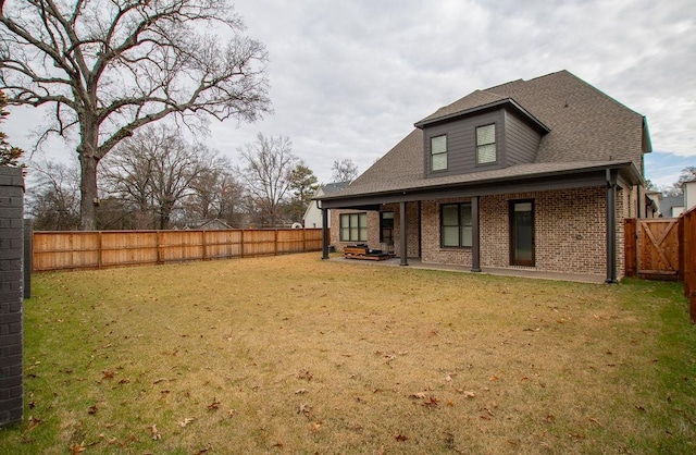 back of property featuring a yard and a patio