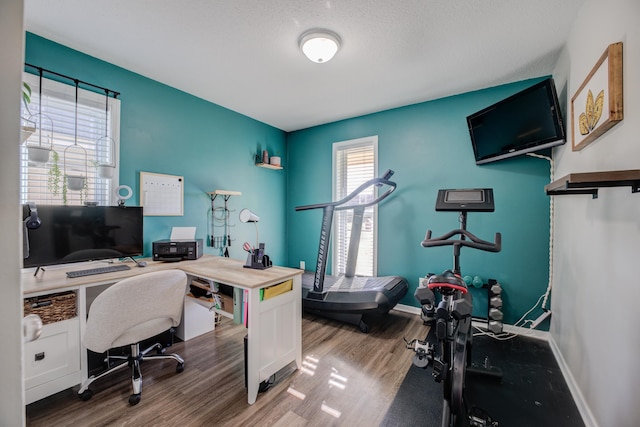 home office with hardwood / wood-style floors and a textured ceiling