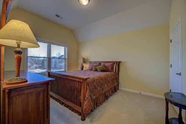 bedroom featuring lofted ceiling and light carpet