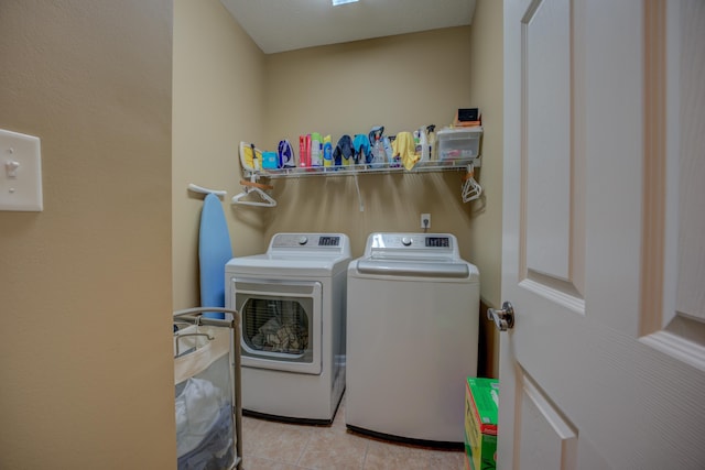 laundry room featuring separate washer and dryer and light tile patterned floors