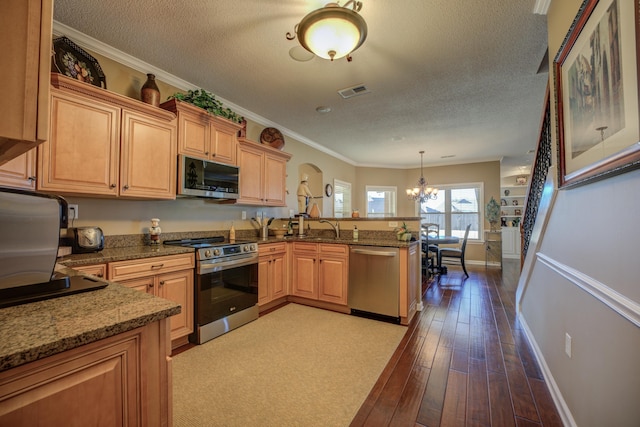 kitchen with kitchen peninsula, stainless steel appliances, decorative light fixtures, a notable chandelier, and light hardwood / wood-style floors