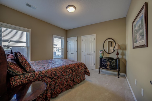 carpeted bedroom featuring multiple closets