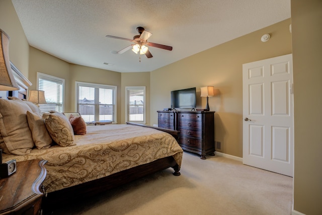 carpeted bedroom featuring ceiling fan and a textured ceiling