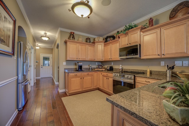 kitchen with light brown cabinetry, a textured ceiling, stainless steel appliances, crown molding, and hardwood / wood-style flooring