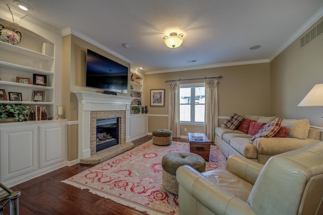 living room featuring built in shelves, dark hardwood / wood-style flooring, ornamental molding, and a tile fireplace