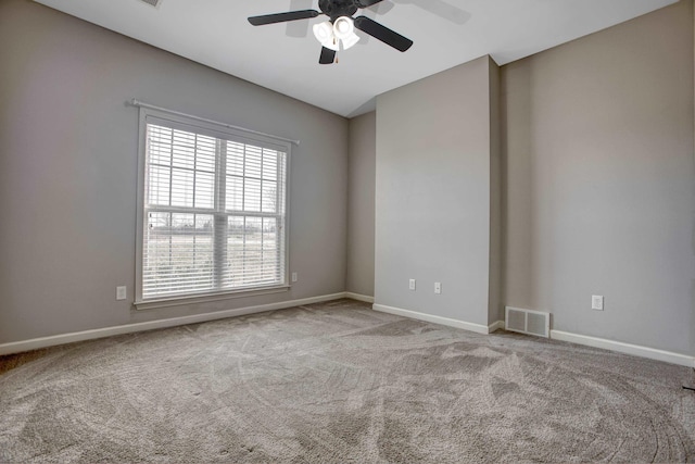 carpeted spare room featuring ceiling fan