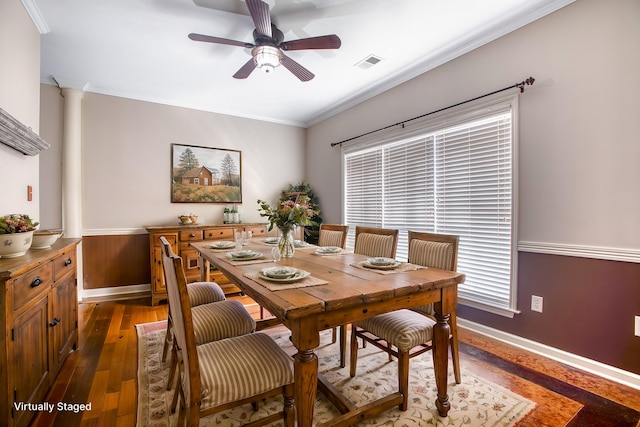 dining room featuring decorative columns, ceiling fan, ornamental molding, and dark wood-type flooring