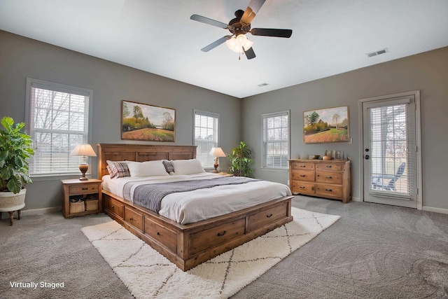 carpeted bedroom with ceiling fan, multiple windows, and access to exterior