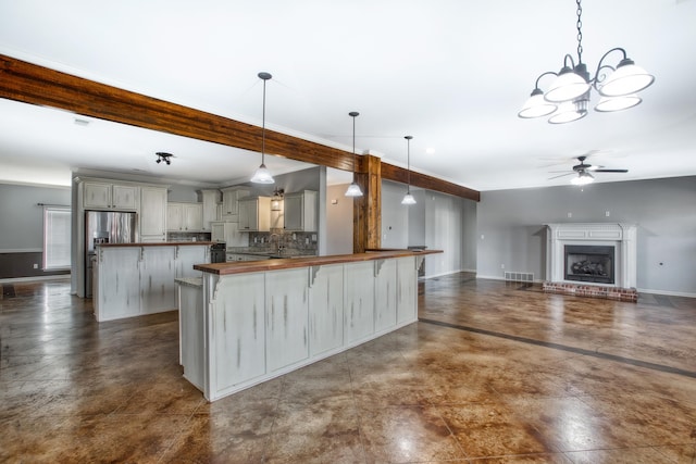 kitchen with hanging light fixtures, stainless steel fridge with ice dispenser, beamed ceiling, backsplash, and ceiling fan with notable chandelier