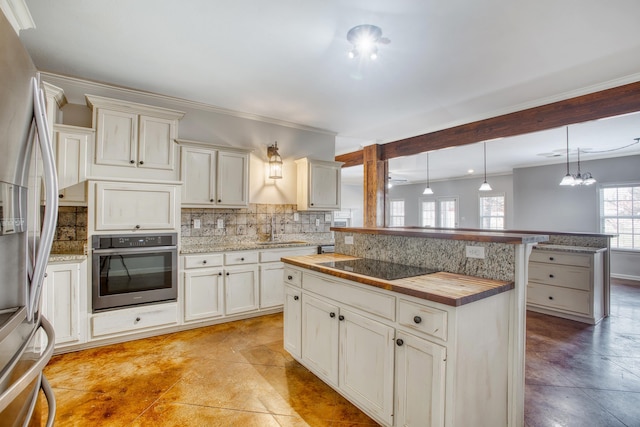 kitchen featuring pendant lighting, a center island, stainless steel appliances, backsplash, and sink