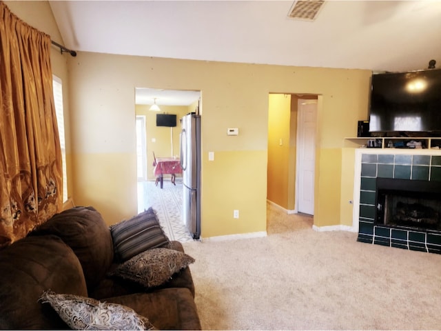 living room featuring a fireplace and light colored carpet