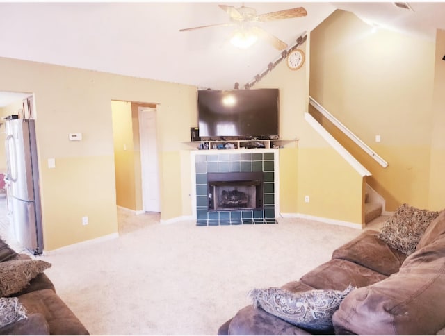 living room with ceiling fan, light colored carpet, and a fireplace