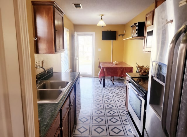 kitchen featuring stainless steel fridge, sink, and range