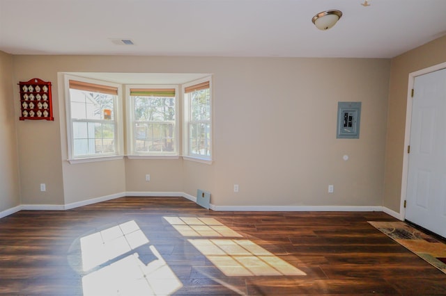 entrance foyer with dark hardwood / wood-style flooring, a wealth of natural light, and electric panel