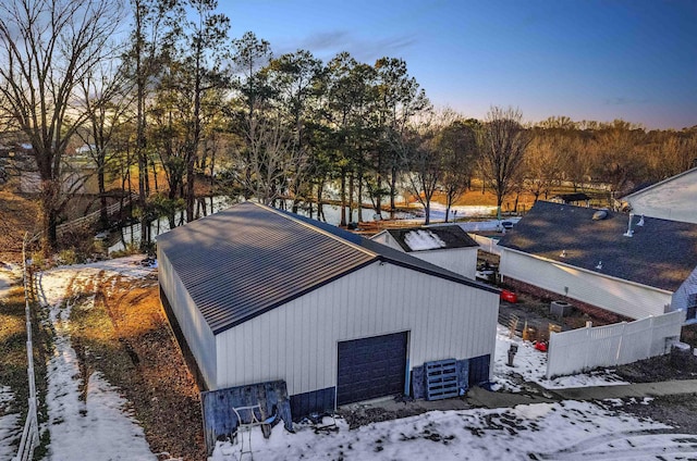 view of snowy exterior with cooling unit and a garage