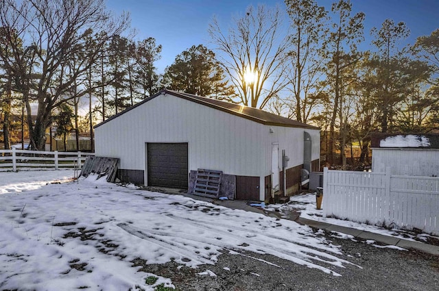 snow covered structure with a garage