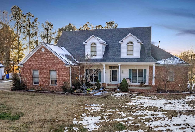 view of front of home featuring covered porch and a lawn