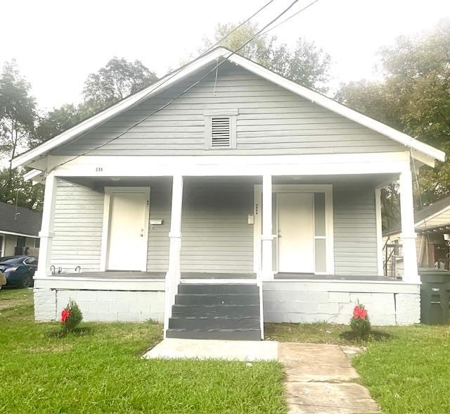 bungalow-style home with a porch and a front lawn