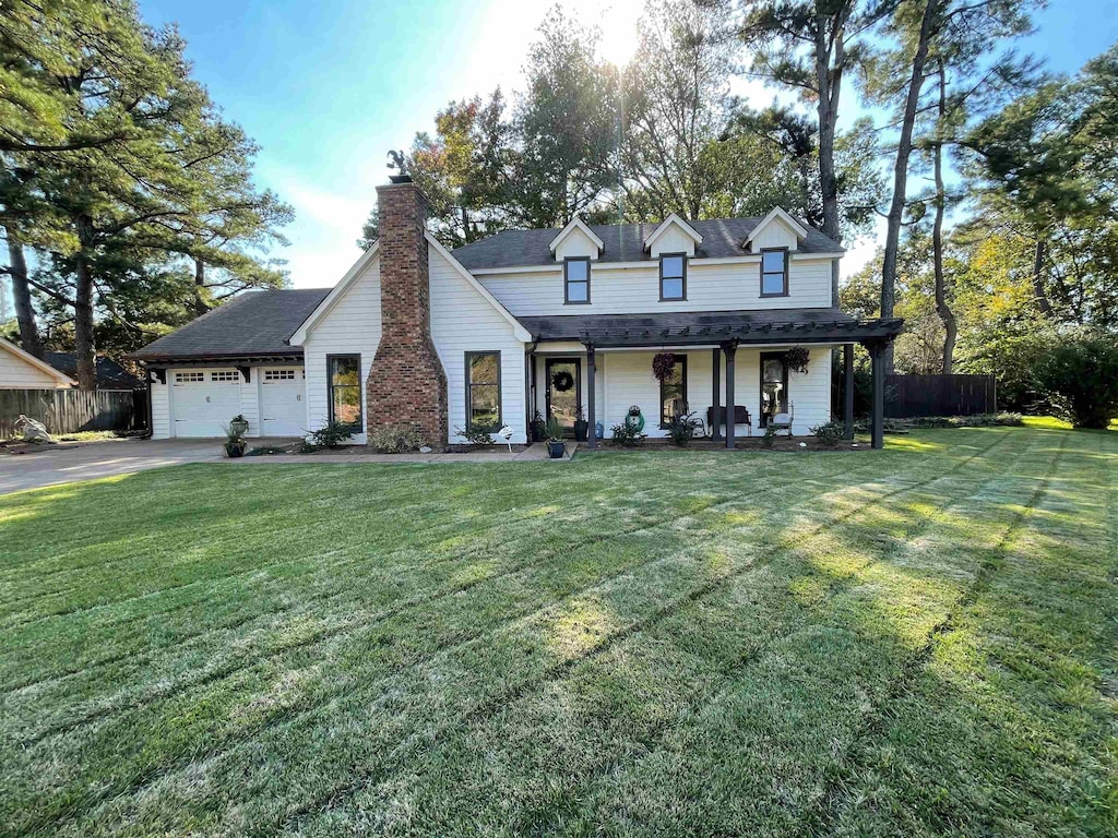 view of front of home featuring a front lawn, a porch, and a garage