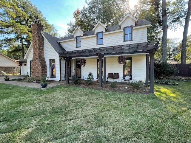 view of front of property with a front yard, a pergola, and a patio area