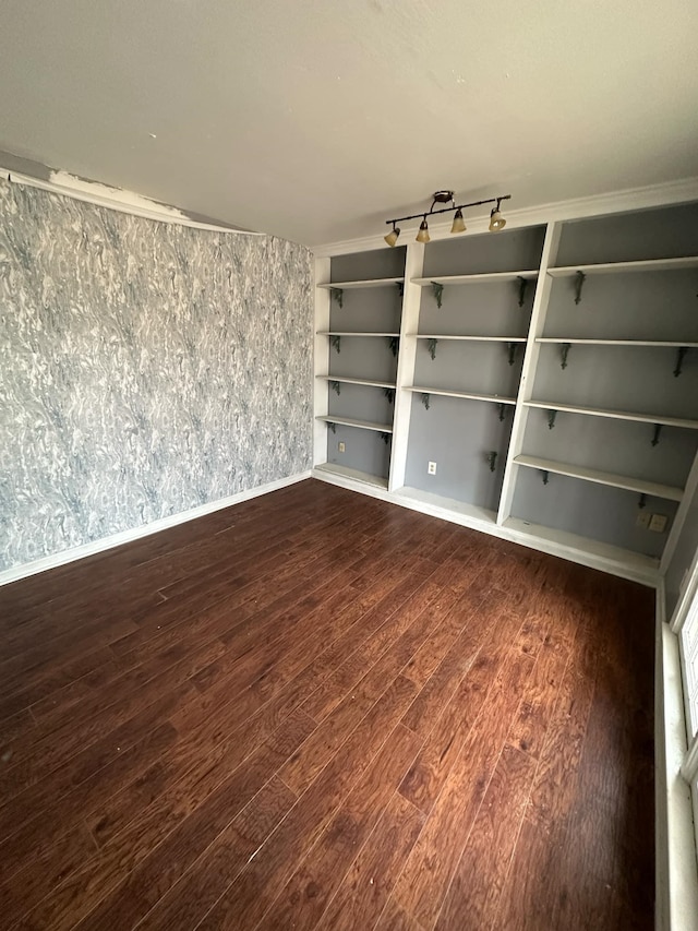 empty room featuring ornamental molding and dark wood-type flooring